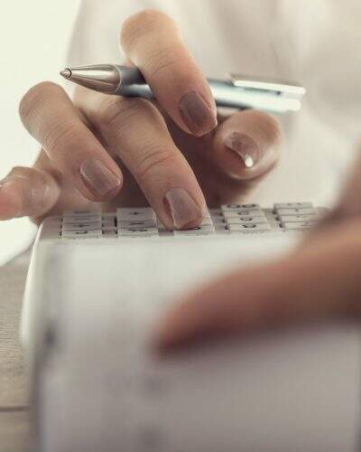 Closeup low angle view of a woman using a manual adding machine